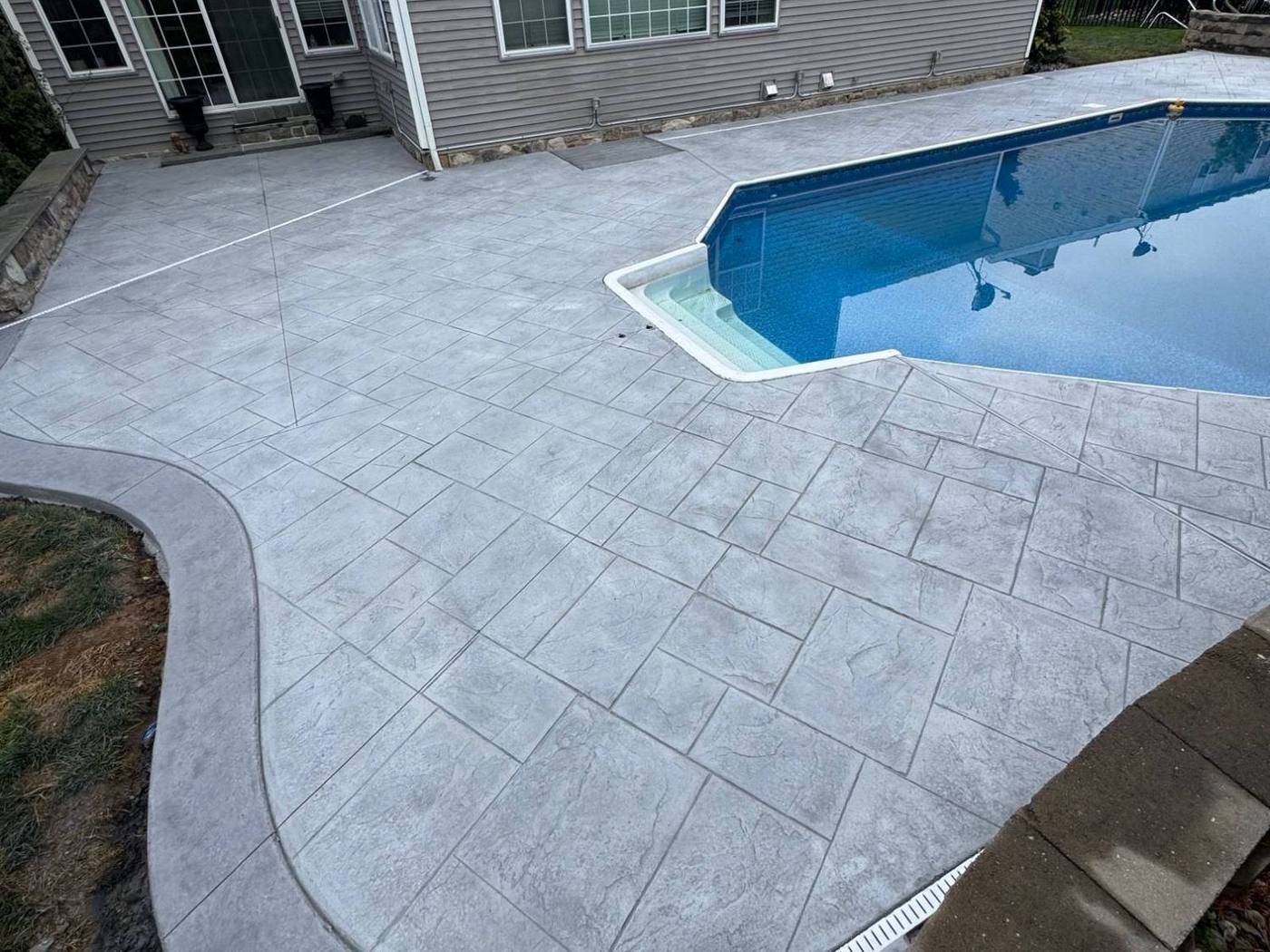 Stamped concrete pool deck around an in-ground pool
