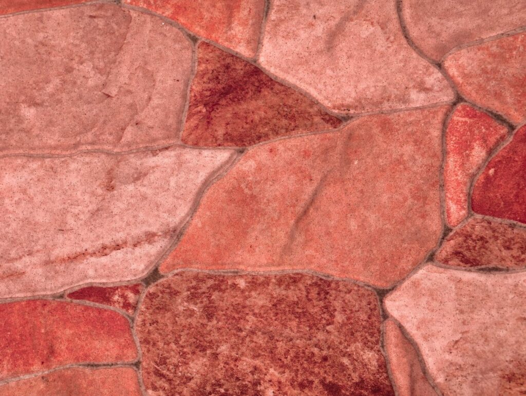 Warm and inviting red coral stone wall texture featuring irregular shaped natural rocks in rich terracotta, salmon pink, and deep crimson hues. This earthy background showcases organic stone formations with varied color tones, weathered surfaces, and authentic masonry patterns perfect for Mediterranean restaurant branding, rustic café interiors, artisan bakery materials, wine bar designs, Tuscan villa marketing, southwestern architectural projects, pottery studio visuals, clay workshop promotions, harvest festival themes, and warm hospitality concepts. The ultra-high resolution image captures natural geological variations, textured stone surfaces, and harmonious color blending that adds warmth and character to any creative application. Ideal for designers seeking cozy, inviting backgrounds for farm-to-table restaurants, organic food brands, cultural heritage projects, regional tourism campaigns, or any project requiring an authentic, earthy aesthetic with Mediterranean charm and traditional craftsmanship appeal.
